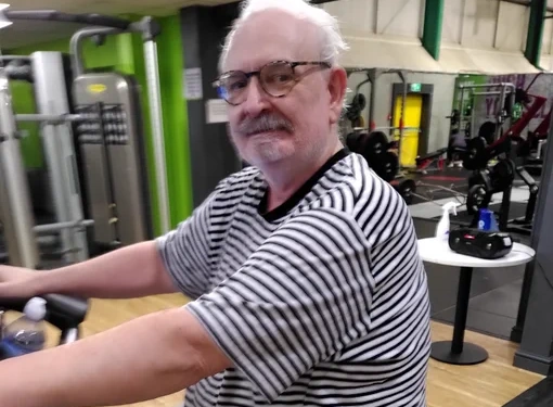Image shows Duncan using an exercise bike in the gym